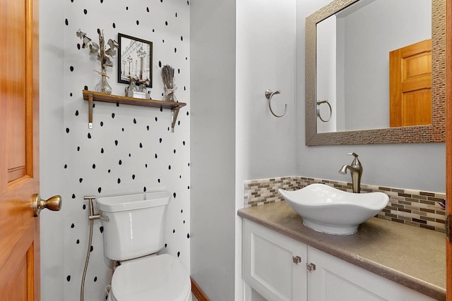 half bathroom featuring toilet, decorative backsplash, and vanity