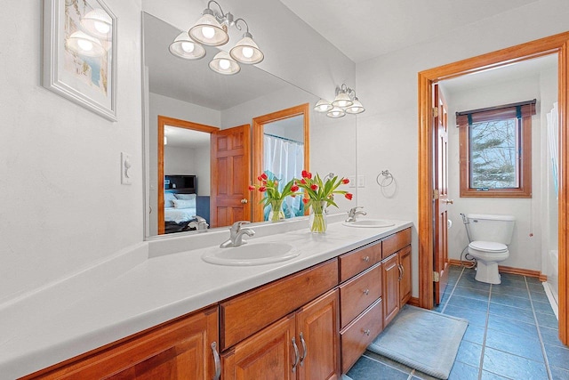 ensuite bathroom featuring a sink, toilet, double vanity, and ensuite bath