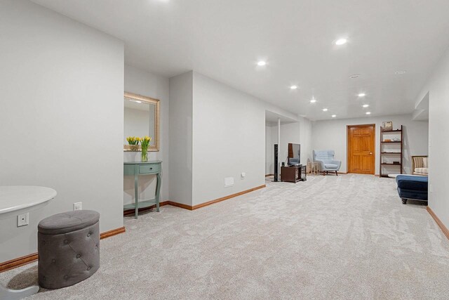sitting room with baseboards, recessed lighting, and carpet