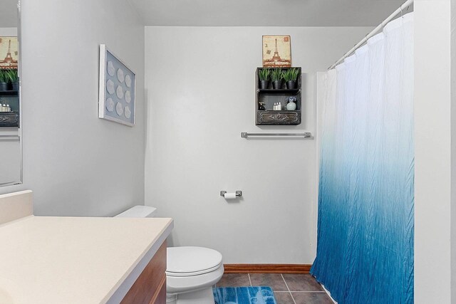 full bath featuring a shower with shower curtain, vanity, baseboards, tile patterned flooring, and toilet