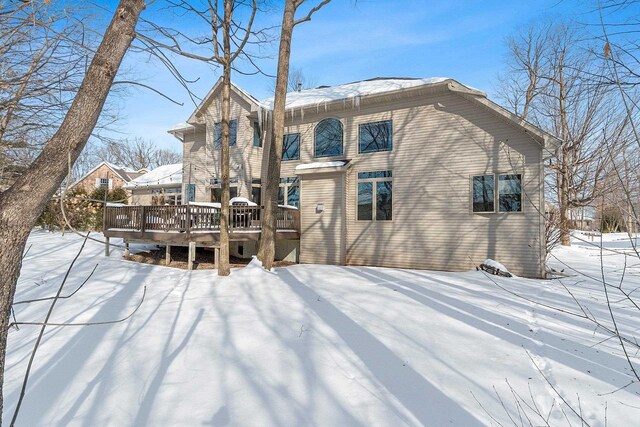 snow covered house featuring a deck