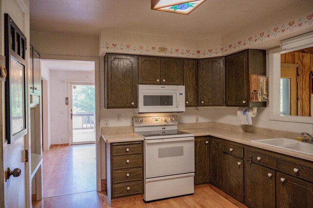 1930 Czech Ave, Arkdale, WI 54613 - kitchen featuring light countertops, white appliances, dark brown cabinets, a sink, and light wood-type flooring