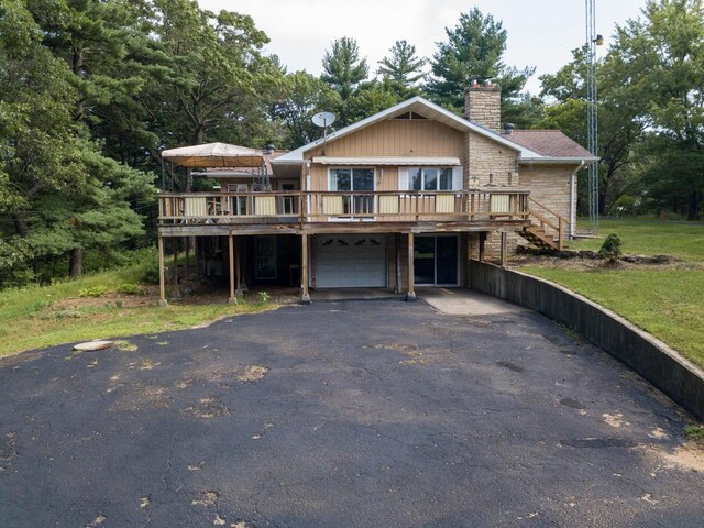 1930 Czech Ave, Arkdale, WI 54613 - view of front facade featuring driveway, a wooden deck, an attached garage, and a chimney