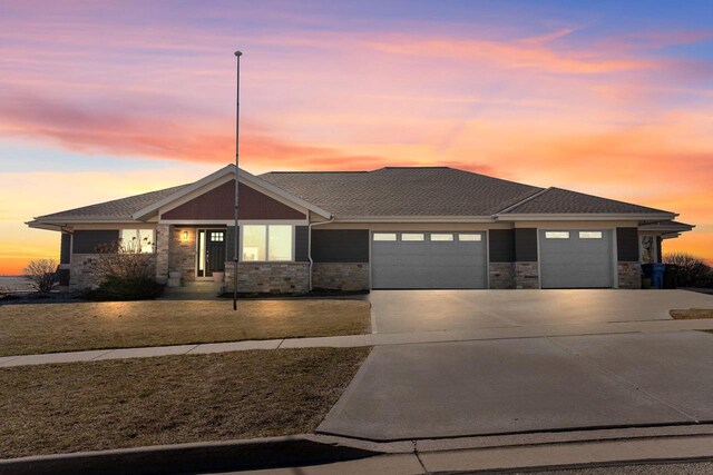 1833 Danny Dr, Mount Horeb, WI 53572 - view of front of house with stone siding, driveway, a garage, and roof with shingles