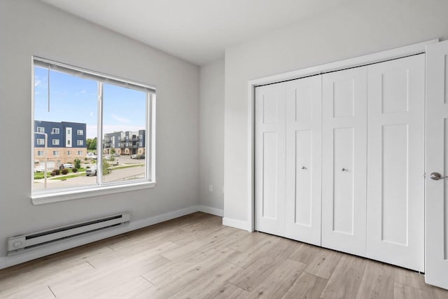 1501 N Windsor Ave Unit 205, Cottage Grove, WI 53527 - unfurnished bedroom with a baseboard heating unit, light wood-style floors, and a closet