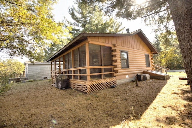 N16180 Deerfield Dr, Nekoosa, WI 54457 - rear view of property featuring log siding, a sunroom, and board and batten siding