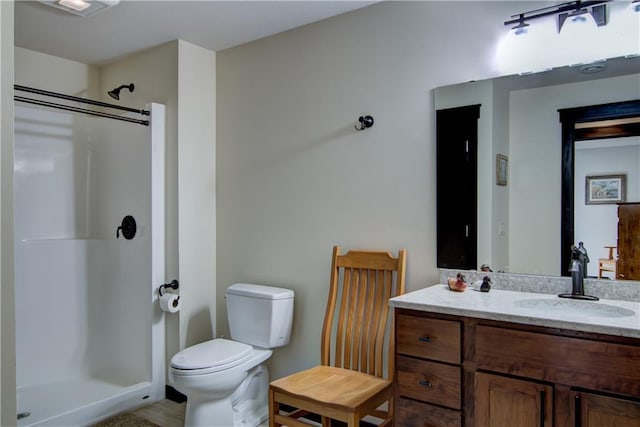 full bath with toilet, vanity, and a shower stall