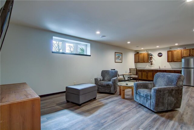 living room with baseboards, wood finished floors, and recessed lighting