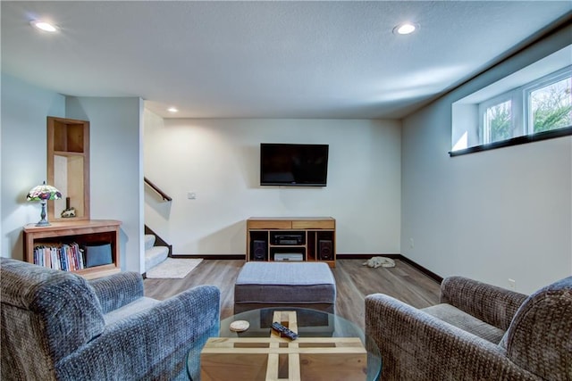 living area with recessed lighting, baseboards, stairway, and wood finished floors
