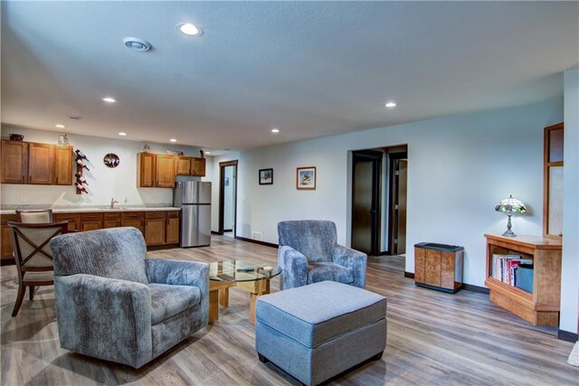 living area featuring recessed lighting, baseboards, and wood finished floors