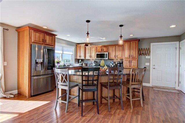 4884 Priory Rd, Eau Claire, WI 54701 - kitchen with decorative backsplash, a sink, wood finished floors, and appliances with stainless steel finishes