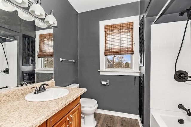 full bathroom featuring toilet, plenty of natural light, baseboards, and wood finished floors