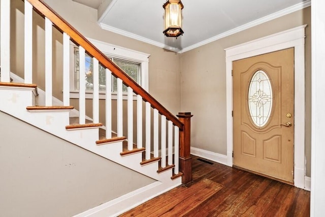 foyer entrance featuring baseboards, wood finished floors, stairway, and crown molding