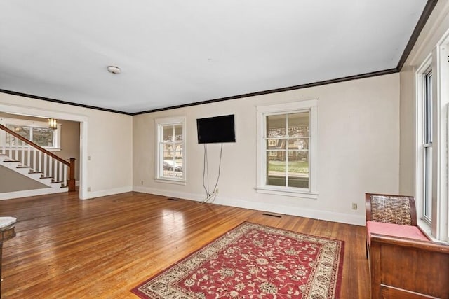 interior space featuring crown molding, wood finished floors, and stairway