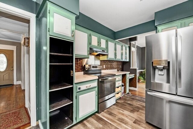 kitchen with light countertops, green cabinets, wood finished floors, under cabinet range hood, and stainless steel appliances