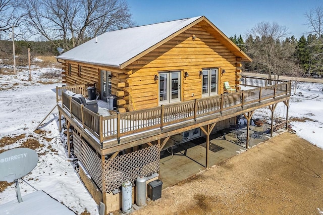 N9805 County Road Aa, Portage, WI 53901 - snow covered house with log siding, a deck, and a patio