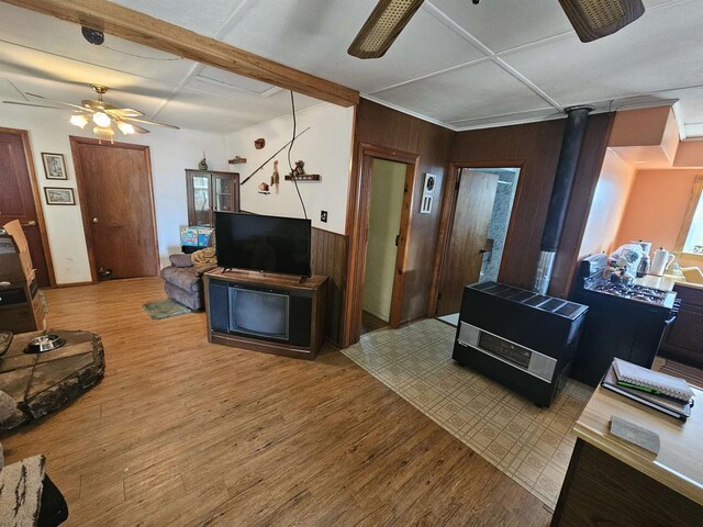 N2709 Lakeshore Dr, Montello, WI 53949 - living room with wooden walls, ceiling fan, wood finished floors, beam ceiling, and a wood stove