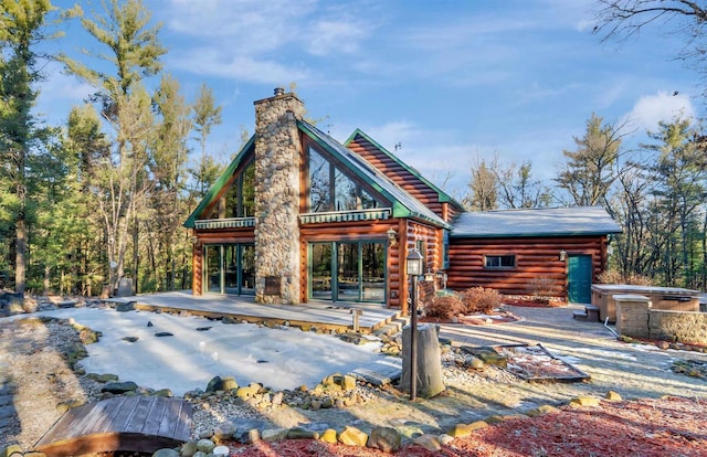 W7113 Bighorn Ct, Wautoma, WI 54982 - back of house featuring a chimney, a wooden deck, and log exterior