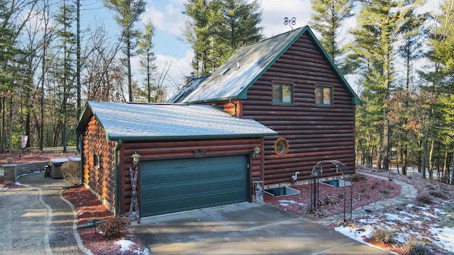 W7113 Bighorn Ct, Wautoma, WI 54982 - view of property exterior featuring log siding, a garage, and concrete driveway