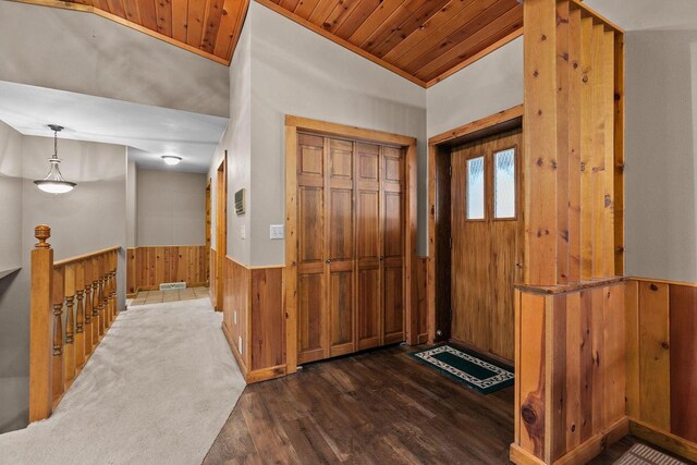 entryway featuring a wainscoted wall, wood ceiling, wood finished floors, wood walls, and lofted ceiling