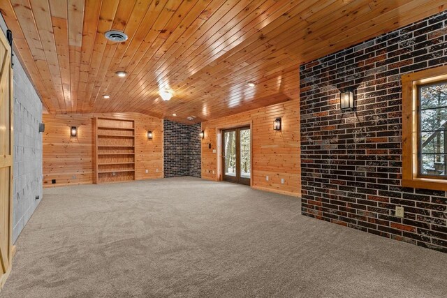 empty room with wood walls, carpet flooring, wood ceiling, brick wall, and visible vents