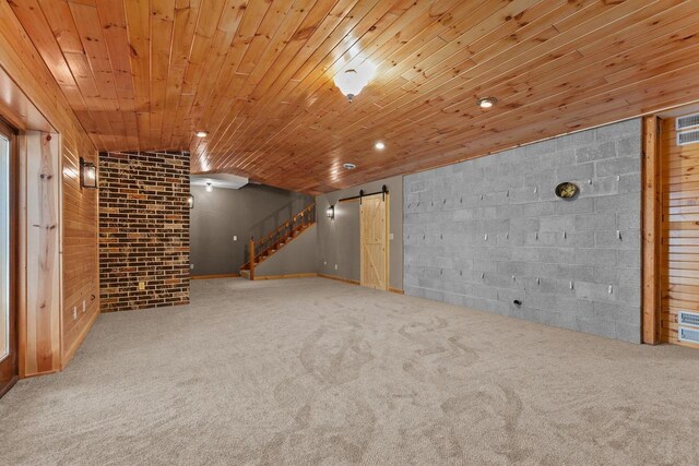finished basement with a barn door, carpet, stairway, and wood ceiling