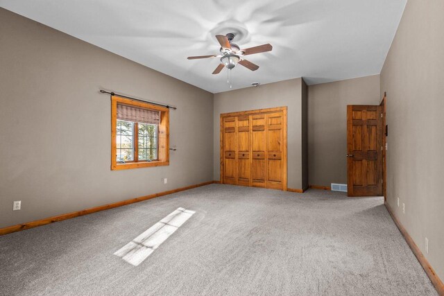 unfurnished bedroom with a closet, visible vents, baseboards, a ceiling fan, and carpet floors