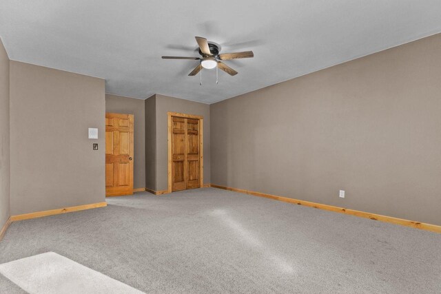 unfurnished room with a ceiling fan, baseboards, and light colored carpet