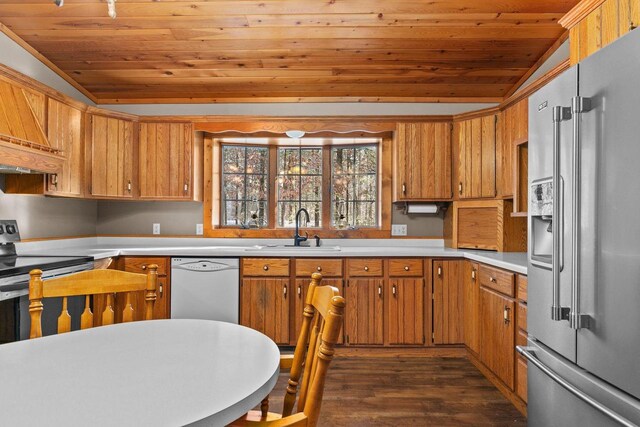 kitchen with light countertops, a sink, vaulted ceiling, and appliances with stainless steel finishes