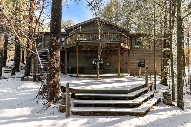 snow covered property with a wooden deck and stairway