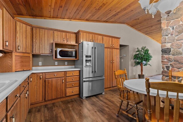 kitchen featuring light countertops, dark wood finished floors, lofted ceiling, stainless steel refrigerator with ice dispenser, and brown cabinetry