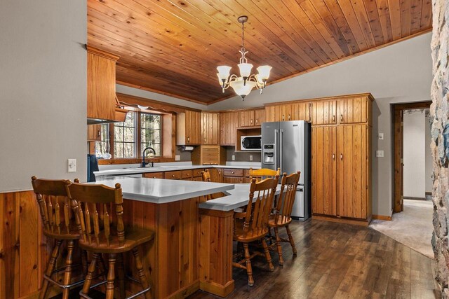 kitchen featuring an inviting chandelier, wooden ceiling, high end refrigerator, dark wood-style floors, and a peninsula