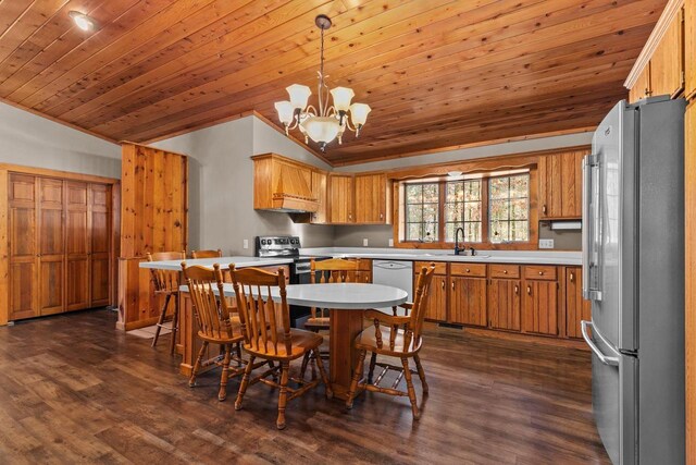 kitchen with light countertops, stainless steel appliances, vaulted ceiling, and dark wood finished floors