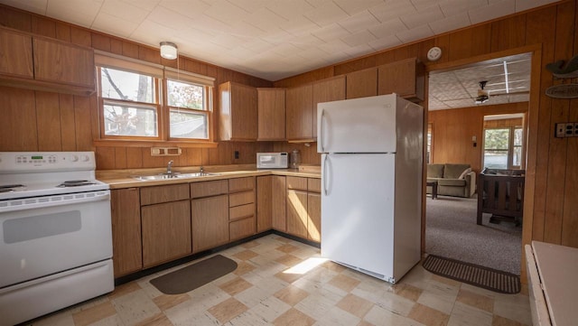 W13573 S Pleasant Rd, Westfield, WI 53964 - kitchen featuring white appliances, a sink, light floors, wooden walls, and light countertops
