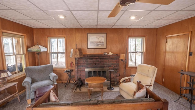 W13573 S Pleasant Rd, Westfield, WI 53964 - living area featuring a brick fireplace, carpet floors, wooden walls, ceiling fan, and a paneled ceiling