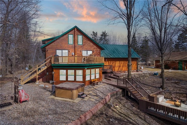 6825 W Lakewood Blvd, Ladysmith, WI 54848 - back of house at dusk featuring stairs, a wooden deck, and a hot tub