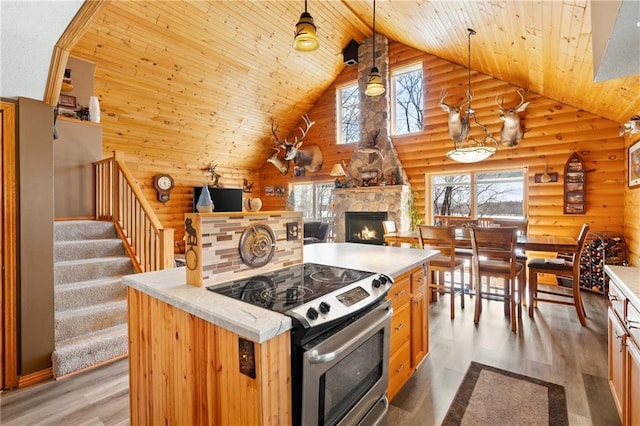 6825 W Lakewood Blvd, Ladysmith, WI 54848 - kitchen featuring high vaulted ceiling, wooden ceiling, light wood finished floors, stainless steel electric range, and a stone fireplace