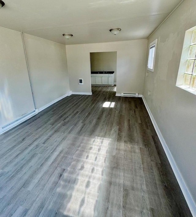 312 S Pearl St, New London, WI 54961 - spare room with baseboards, a baseboard heating unit, and dark wood finished floors