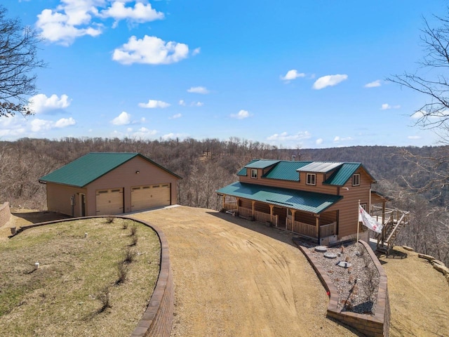 9614 Mississippi Ln, Bagley, WI 53801 - exterior space featuring driveway, metal roof, a wooded view, and an outbuilding