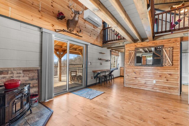 9614 Mississippi Ln, Bagley, WI 53801 - interior space featuring lofted ceiling with beams, wood walls, a wall unit AC, a wood stove, and wood-type flooring