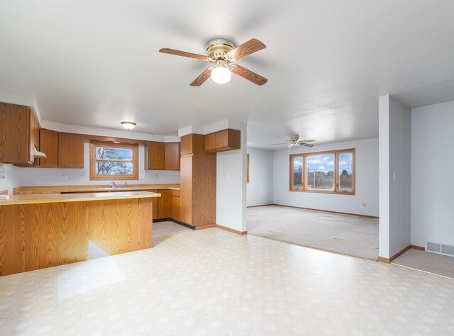 N6741 S Center Rd, Beaver Dam, WI 53916 - kitchen featuring a wealth of natural light, visible vents, brown cabinetry, and a peninsula