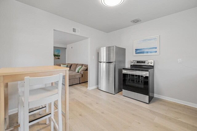 2548 Wallace Lake Rd, West Bend, WI 53090 - kitchen with baseboards, visible vents, stainless steel appliances, and light wood finished floors