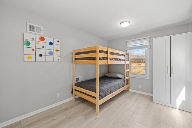 2548 Wallace Lake Rd, West Bend, WI 53090 - unfurnished bedroom featuring wood finished floors, baseboards, and visible vents