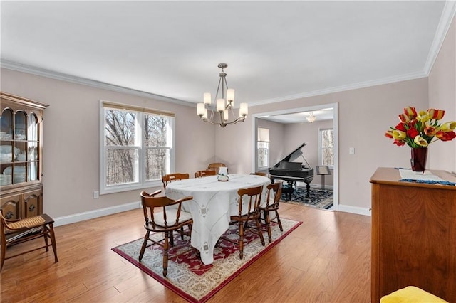 7822 Blue Valley Dr, Eau Claire, WI 54703 - dining room with a notable chandelier, crown molding, light wood-style floors, and baseboards