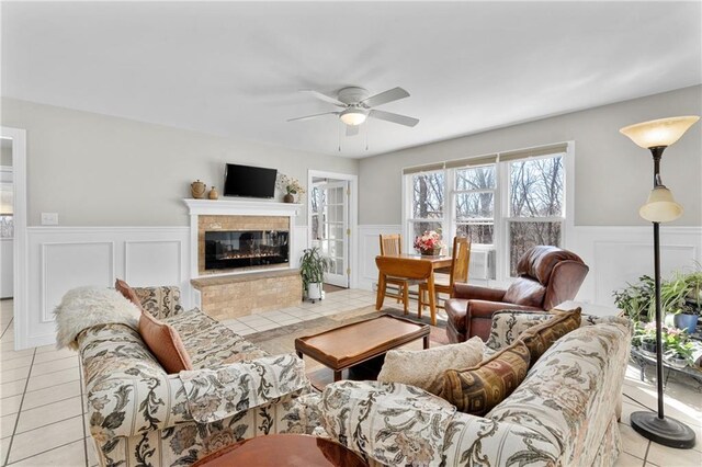 7822 Blue Valley Dr, Eau Claire, WI 54703 - living area with light tile patterned flooring, ceiling fan, a tile fireplace, and a wainscoted wall