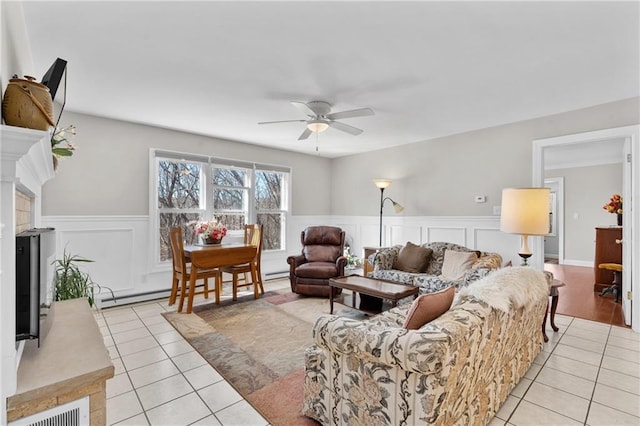 7822 Blue Valley Dr, Eau Claire, WI 54703 - living area with wainscoting, a baseboard heating unit, light tile patterned floors, visible vents, and ceiling fan