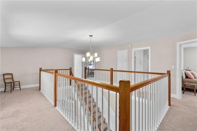 7822 Blue Valley Dr, Eau Claire, WI 54703 - hall with baseboards, a notable chandelier, an upstairs landing, and carpet floors