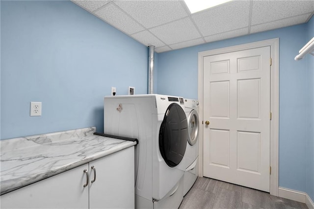 7822 Blue Valley Dr, Eau Claire, WI 54703 - clothes washing area with cabinet space, washer and dryer, and light wood finished floors