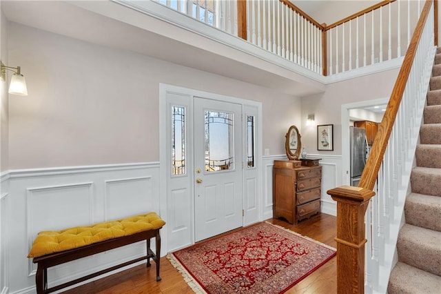 7822 Blue Valley Dr, Eau Claire, WI 54703 - foyer entrance featuring a high ceiling, stairs, wood finished floors, and wainscoting