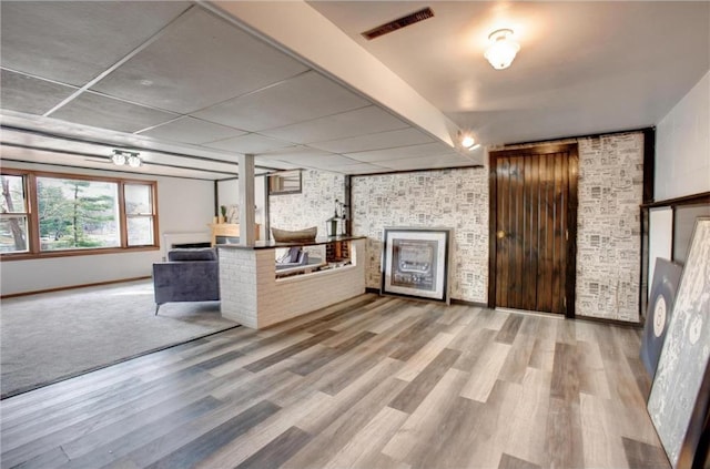 E5512 784th Ave, Menomonie, WI 54751 - unfurnished living room featuring visible vents, brick wall, and wood finished floors